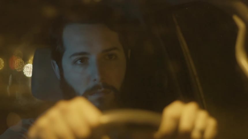 A bearded man drives his car