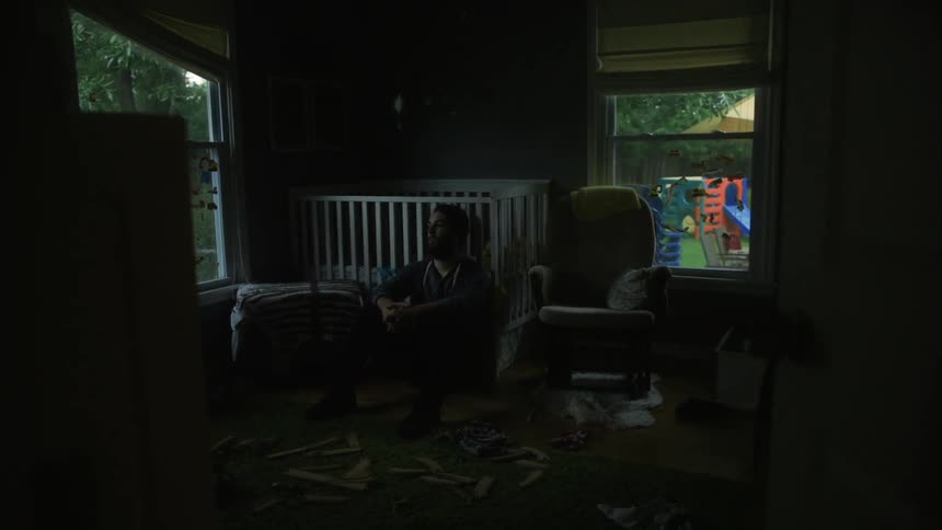 A man is sitting in a dark room