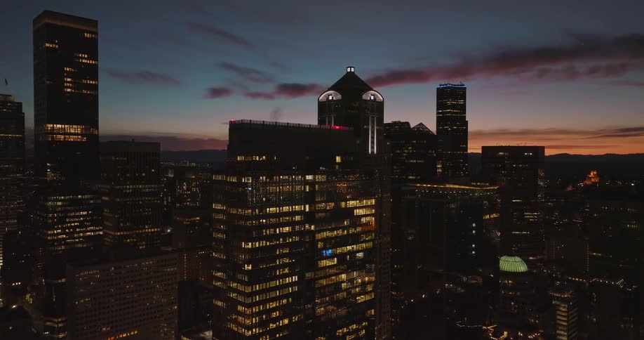 City lights shimmer and shine in the reflections from downtown buildings under a beautiful painted sky