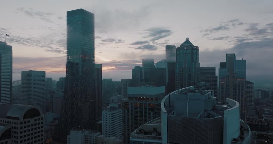 Traverse along the tops of tall downtown skycrapers as the sunrise paints the sky in the distance