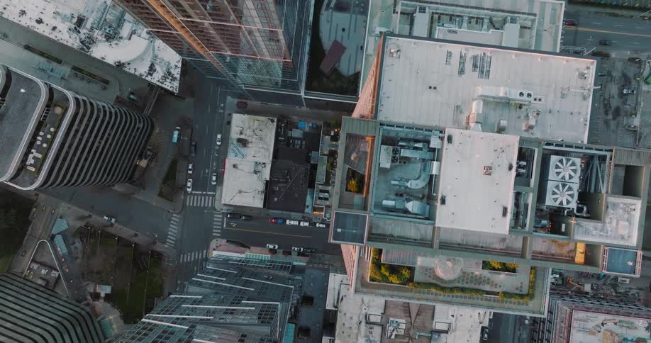 Birds eye view just above the rooftops of urban downtown high rise buildings