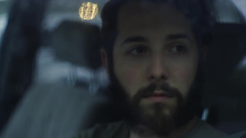 A man is sitting in the car looking to the side