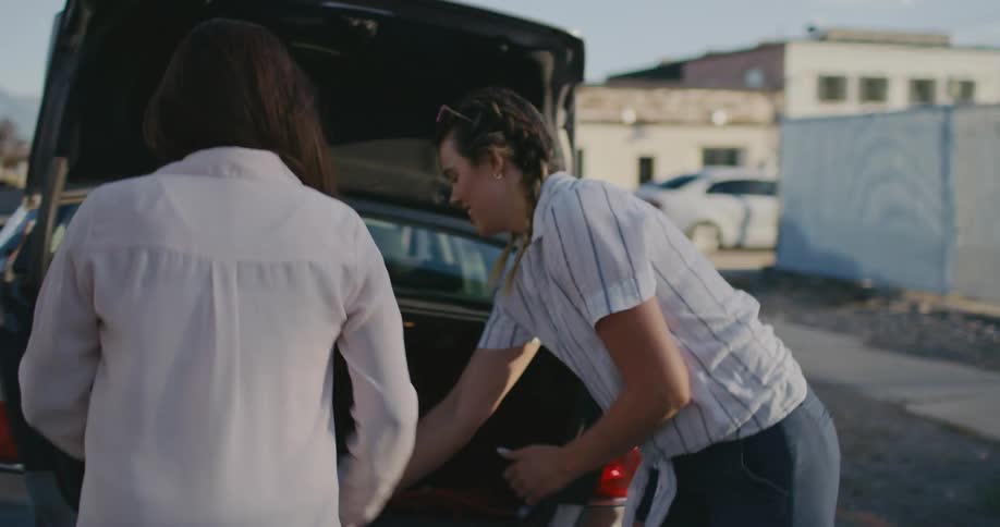 Two women changing a tire on a car