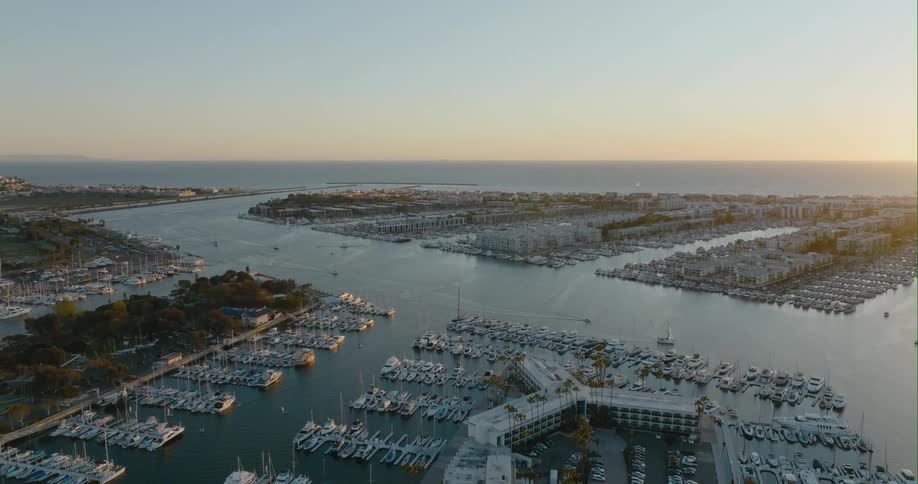 Boats and sailboat traveling down the main waterway of a large tropical marina