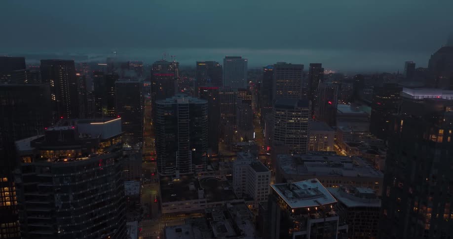 Slow traverse along the tops of high rise buildings at dusk