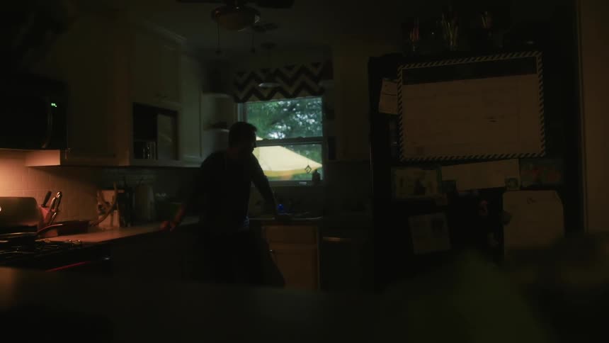 Man stands looking out a house window