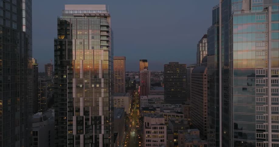 Flying between beautifully lit apartment and condo towers at dusk