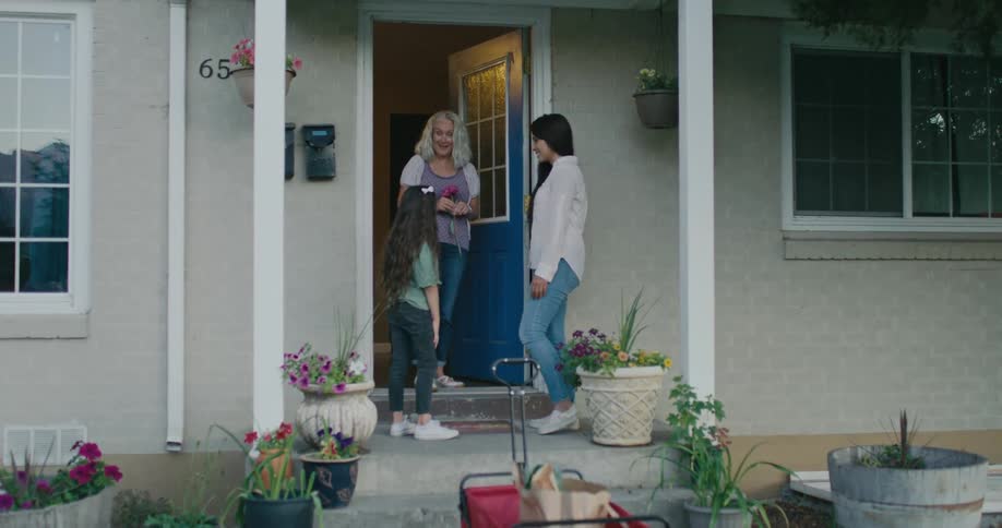 A family is talking outdoors on the front steps together