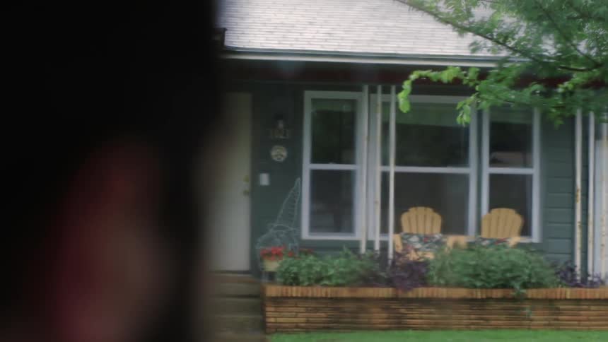 A person looks at a gray house