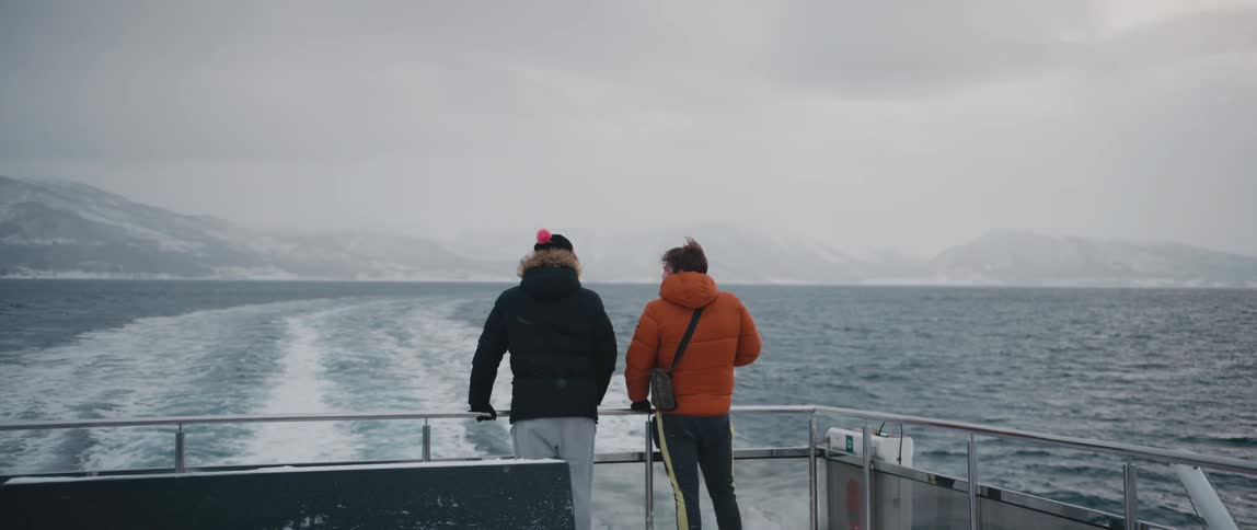 A view of two people standing on a boat