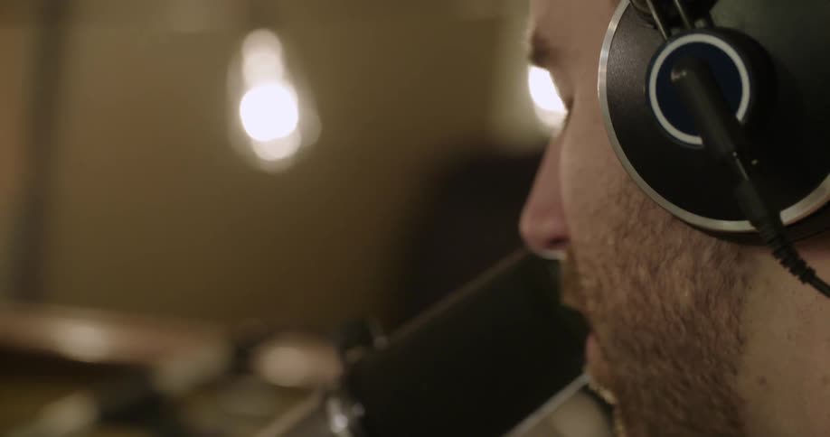 A man sings into a black mic