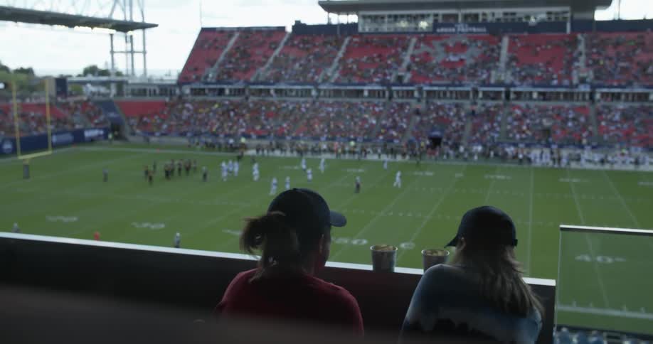Two women talk at a football game