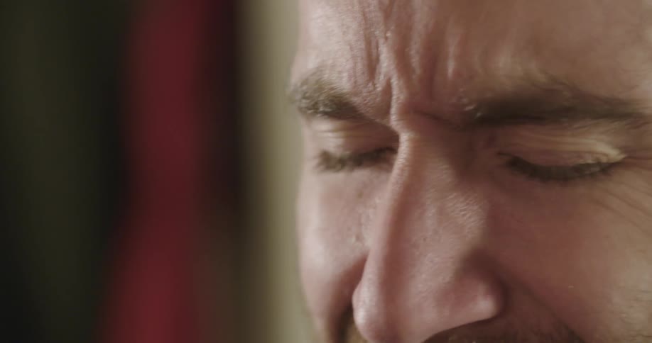 A man shakes his head with his eyes closed