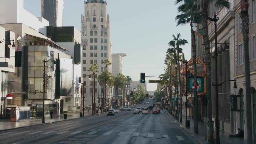Vehicles travel on the city street past the retail stores