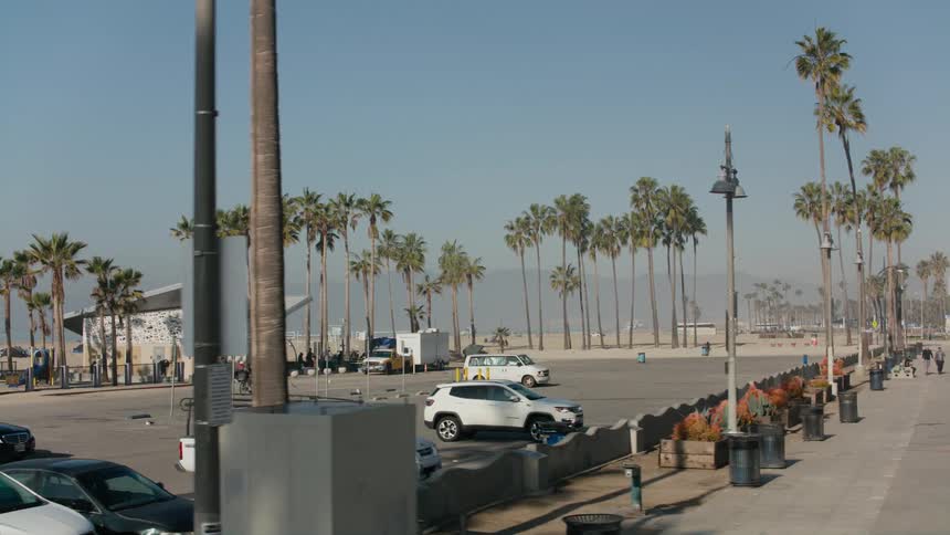 People run and ride bicycles on a park trail near the beach