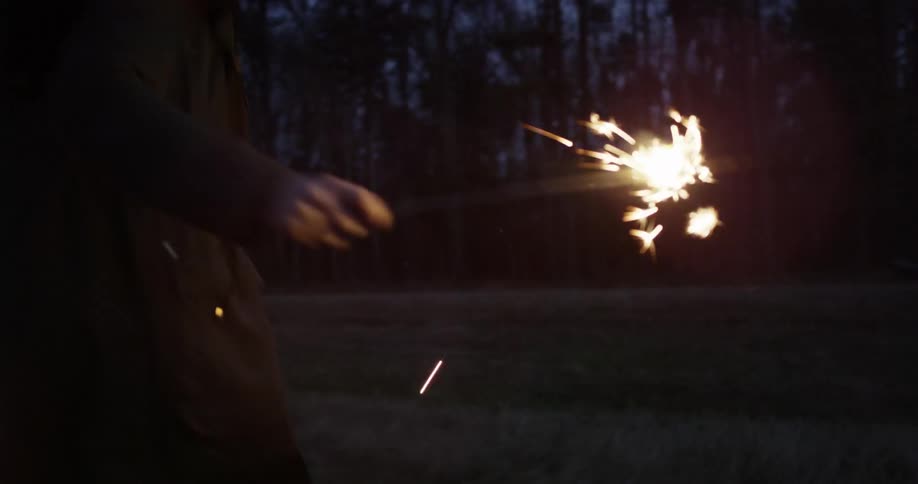 Girl runs with sparkler at night