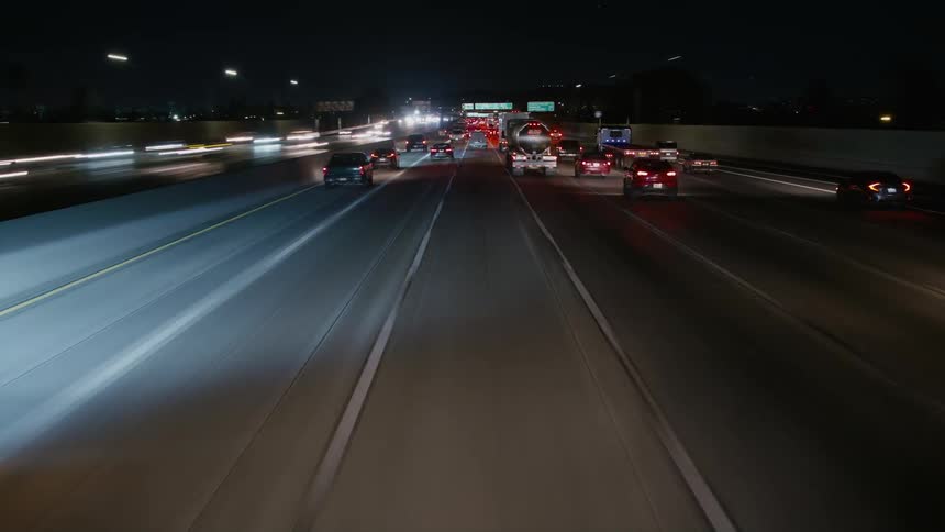 A lot of vehicles driving down the freeway at night