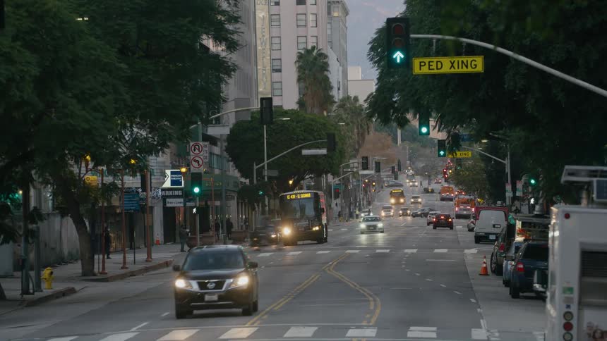 Cars and bus drive on highway at dusk in the city