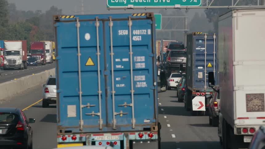Vehicles cut in front of semi trucks during bumper to bumper traffic on the interstate
