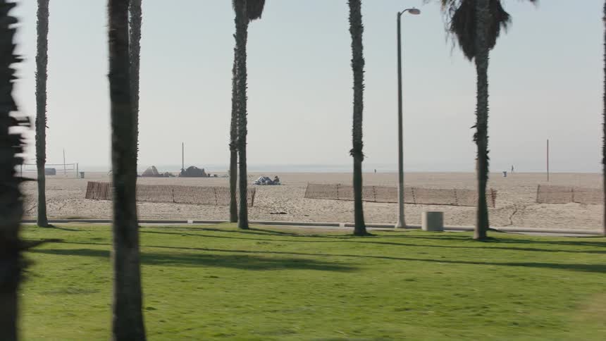 A large public beach near a road on a cloudy day