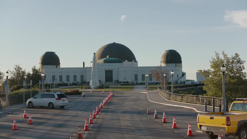 Griffith observatory shrinks as pedestrians walk around it