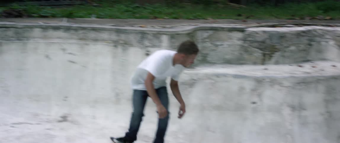 A man is skateboarding in an empty swimming pool