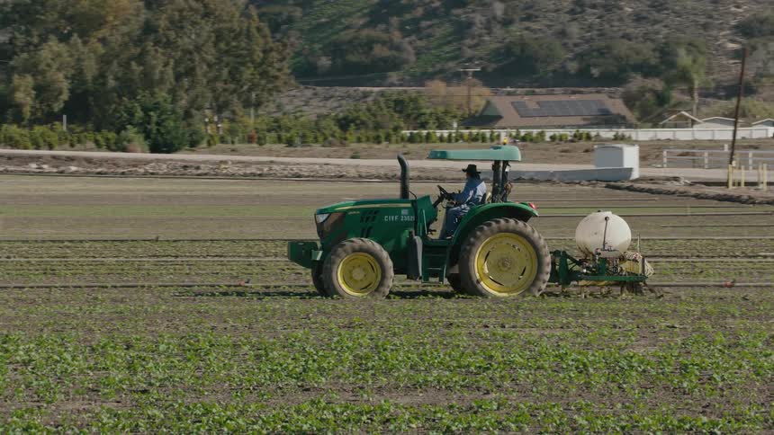 A person plowing a field with a tractor