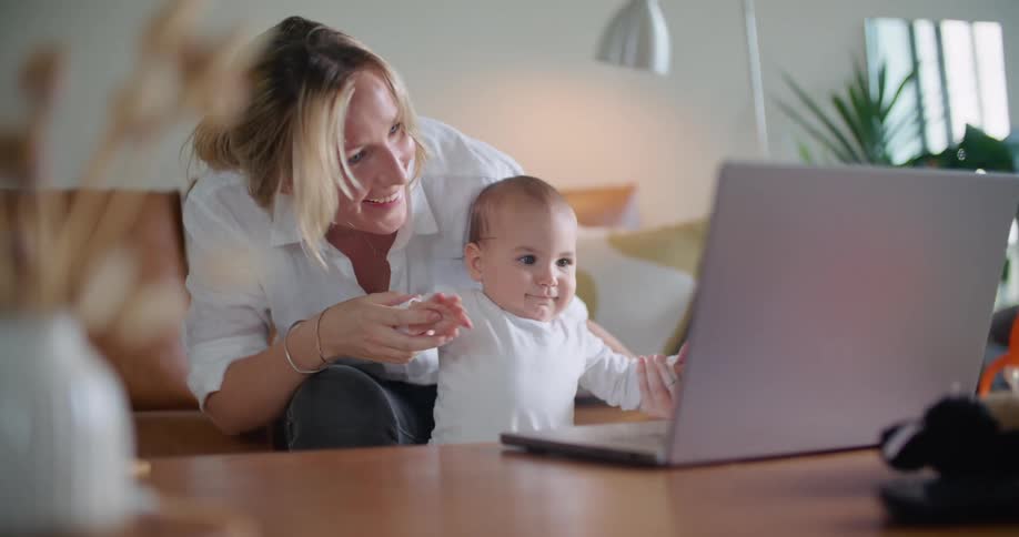 A woman and her daughter on a video call on their couch