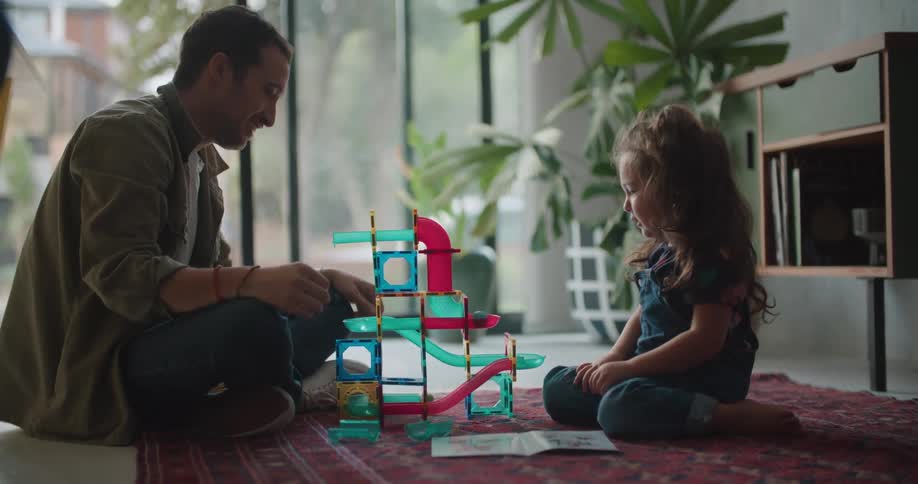 A view of a father and daughter playing with a toy