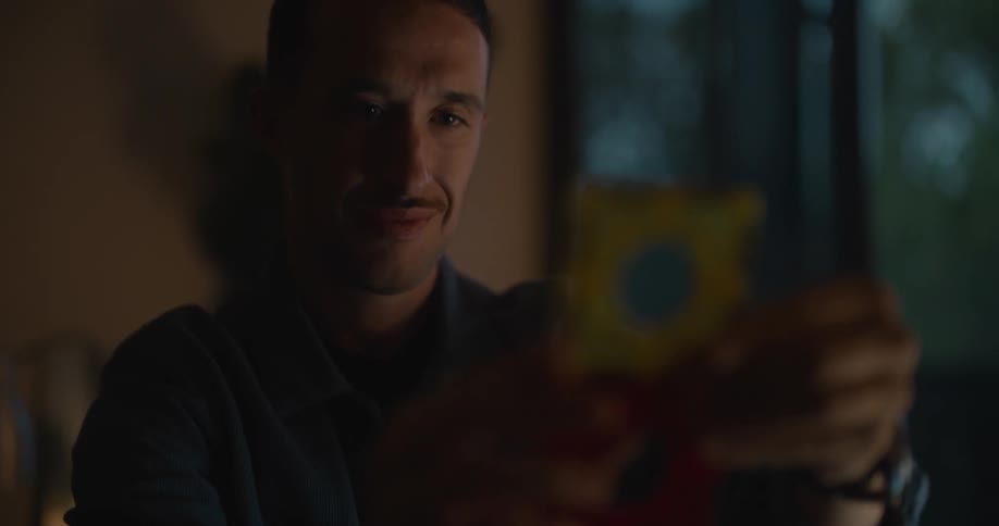 A man smiles after successfully linking two pieces of plastic squares