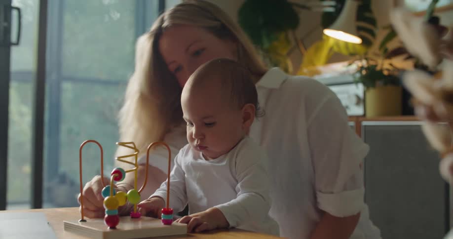 A woman plays with her baby at home