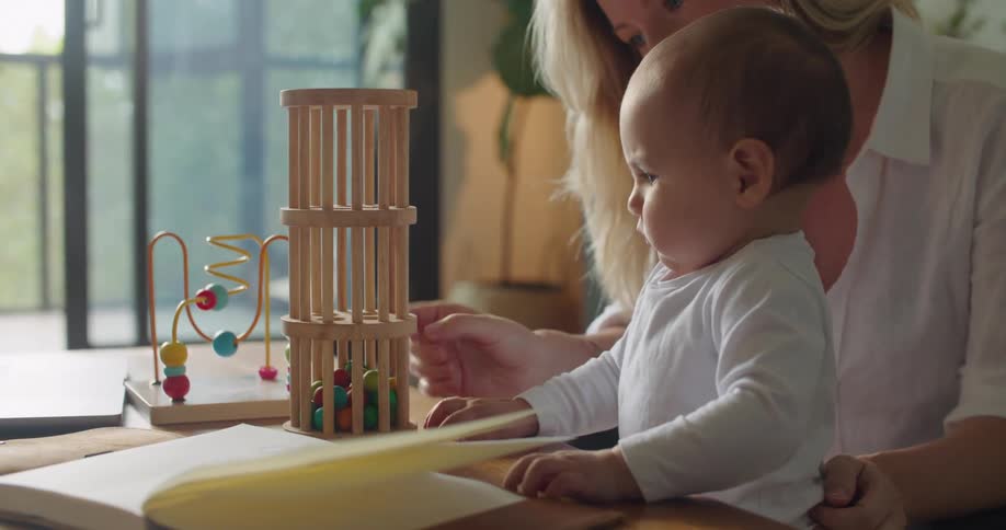 A mother is showing her baby some toys