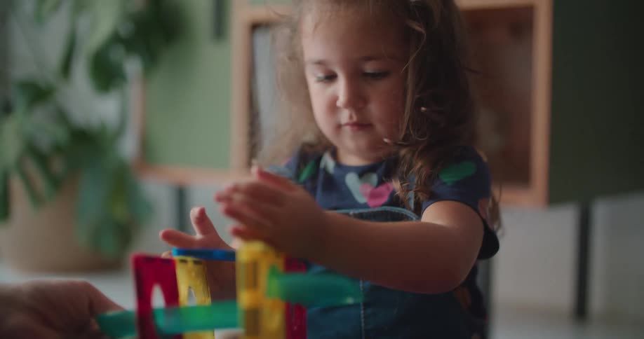 Father plays with his daughter over the rug on the living room at home in the morning