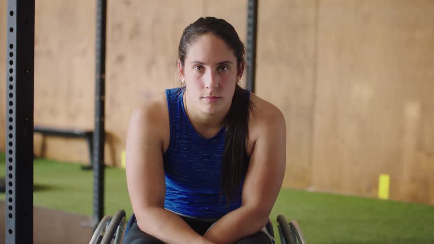 An athletic woman in a wheel chair stares into the camera