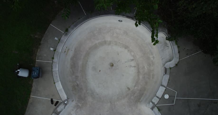 Men skateboard in an empty swimming pool