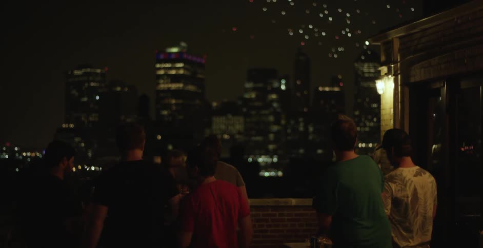 People are watching a fireworks display over a city at night