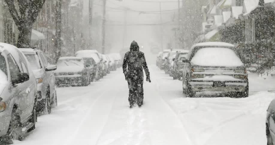 A man walks down a snowy road
