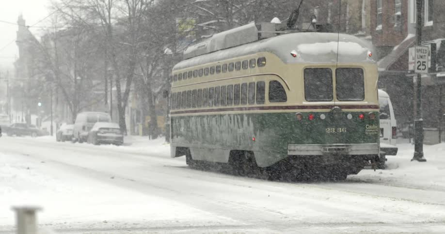 A bus is driving as it snows