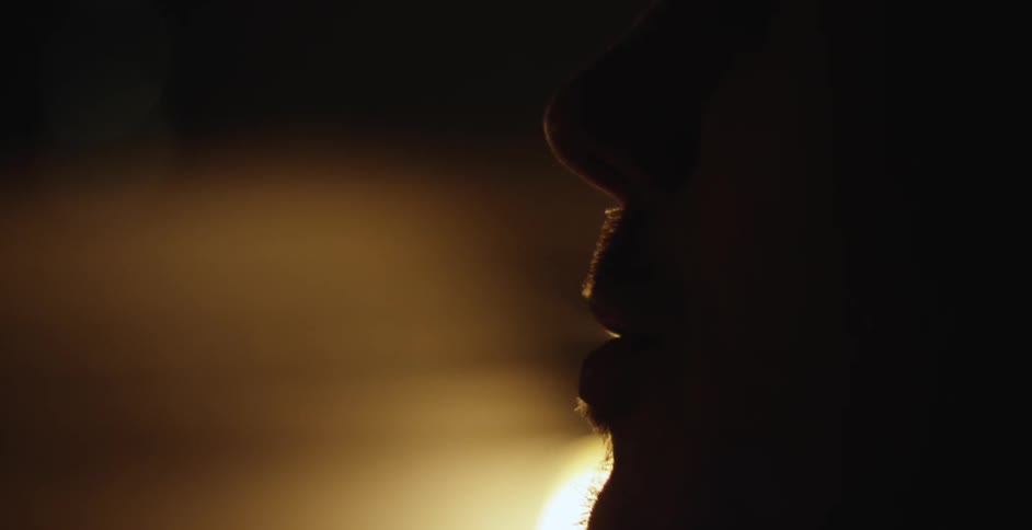 A man is smoking in a dark room