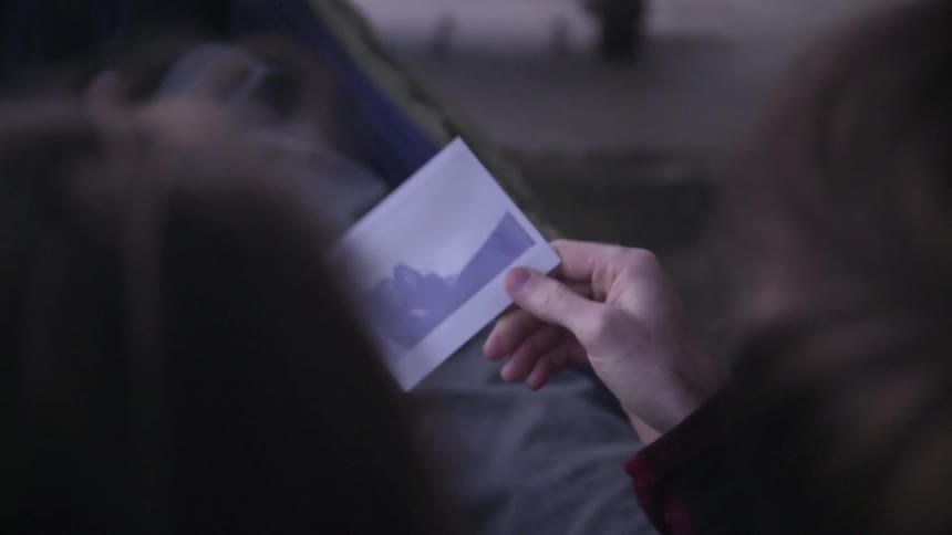 A man is waving a polaroid picture