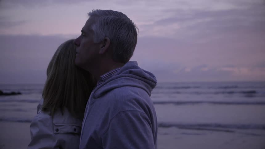 A man and woman dance on the beach