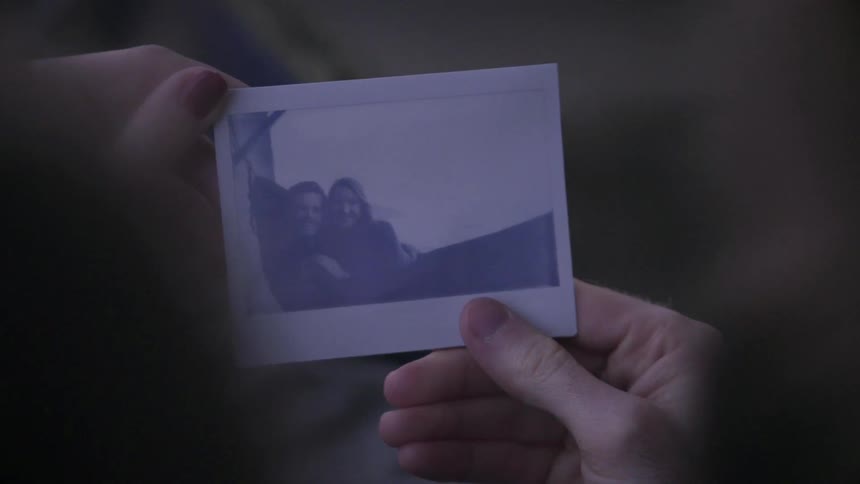 A person is holding a polaroid picture