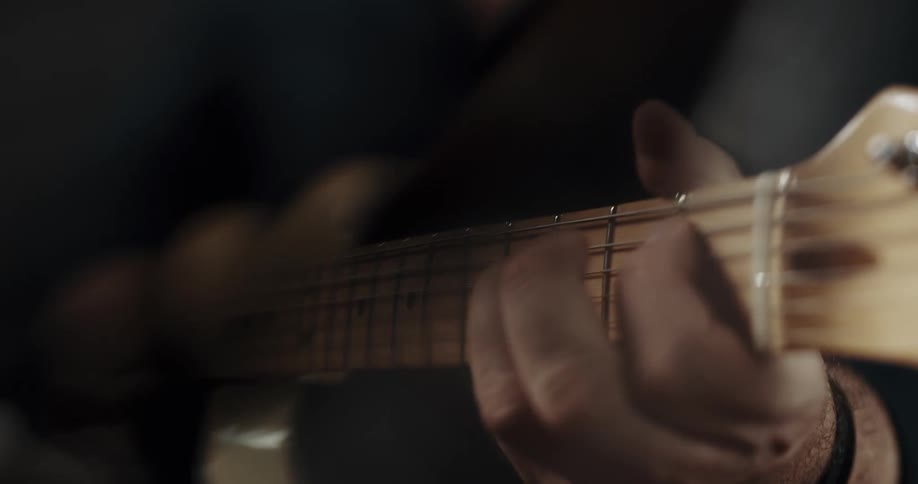 Hand of a man playing a guitar