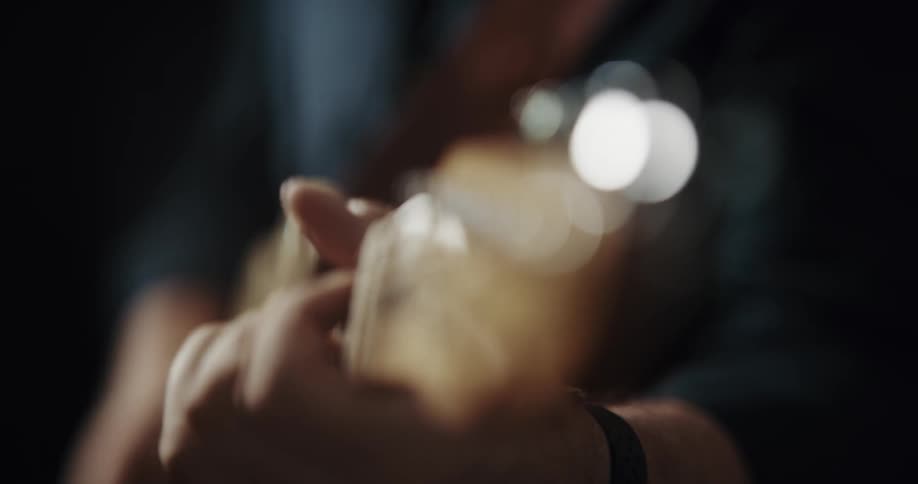 Close up of man playing guitar with plectrum