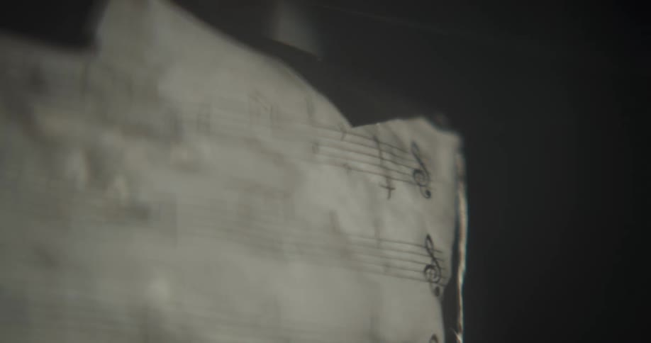 Person handles a musical score in a dark room