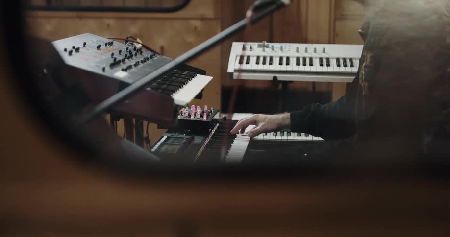 Musician sits in front of keyboard playing