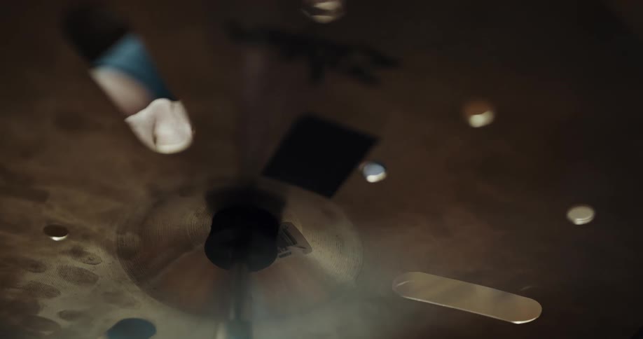 Musician placing a cymbal on a stand inside a studio