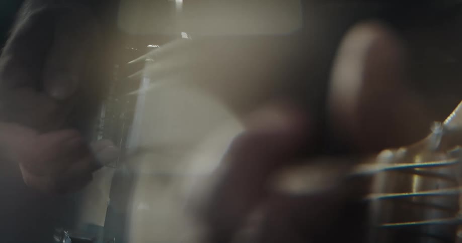 Two hands of a man playing a guitar