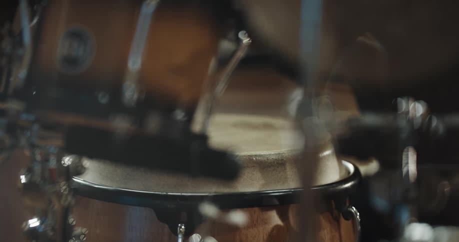 Musician playing the drums with his hands inside a studio