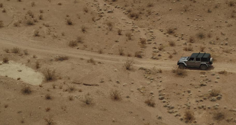 A vehicle is driving in the desert